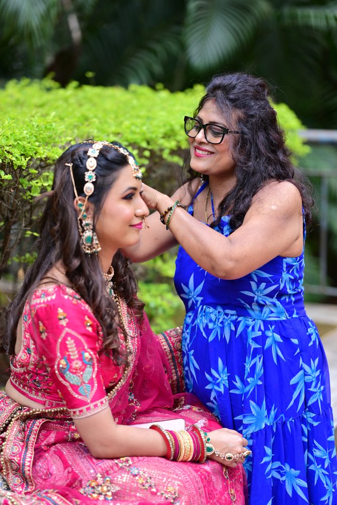 Reena finishing a bride's look with final touches