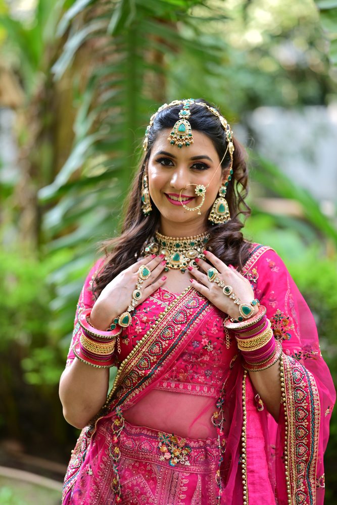 Smiling bride with glowing skin and emerald jewellery