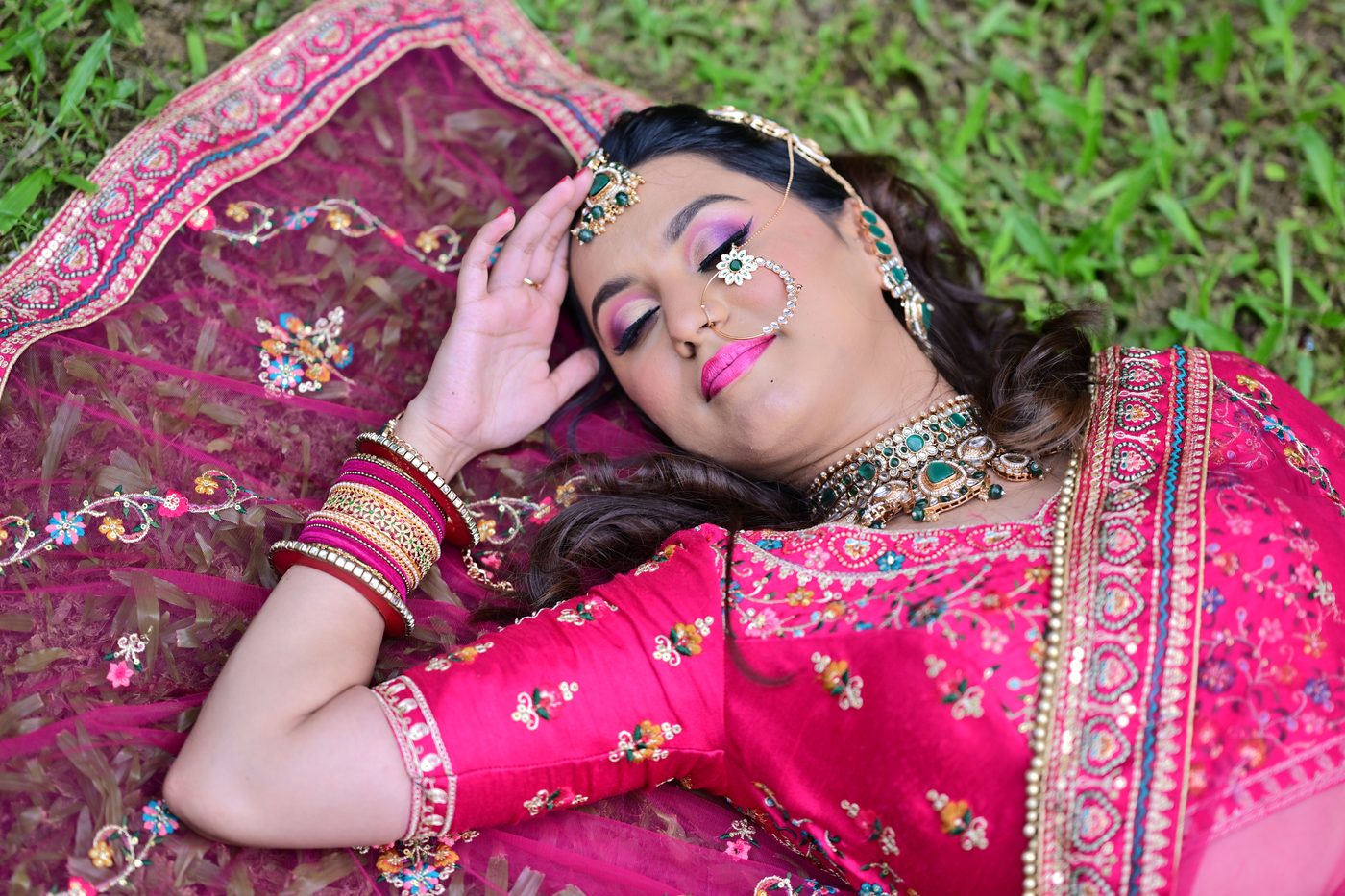 Bride reclining on her dupatta with dewy bridal makeup